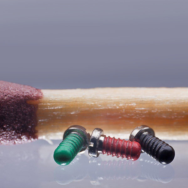 Miniature screws with thread lock coating for the watch industry.