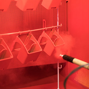 Powder-coated housings in manual coating process.
